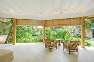 a bedroom with a bed and two chairs and a table at Mosaic Villa Sanur in Sanur