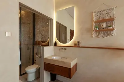 a bathroom with a sink and a toilet and a mirror at Casa Amani 3BR Terracotta Seminyak in Kerobokan