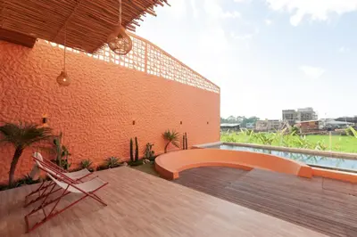 a patio with two chairs and a brick building at Casa Amani 3BR Terracotta Seminyak in Kerobokan