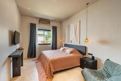 a bedroom with a bed and a window and a couch at Konoha Villa Umalas in Mantaak