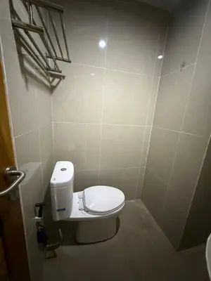 a bathroom with a white toilet in a stall at OKIE HOUSE HOTEL Poppies2 3 min from Kutabeach in Legian