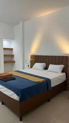 a bedroom with a large bed with a wooden headboard at OKIE HOUSE HOTEL Poppies2 3 min from Kutabeach in Legian