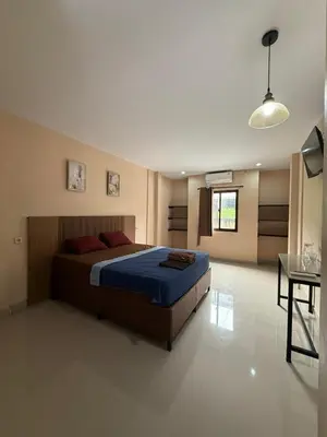 a bedroom with a bed and a table in a room at OKIE HOUSE HOTEL Poppies2 3 min from Kutabeach in Legian