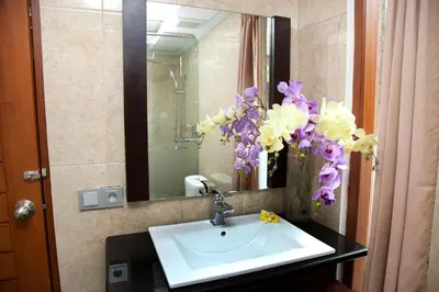 a bathroom with a sink and flowers in a mirror at Jepun Bali Hotel in Kuta