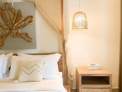 a bedroom with a bed and a bird cage on the wall at Villa Sayang 1 Seminyak in Seminyak