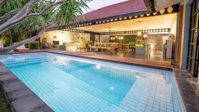 a swimming pool in front of a house at Villa Honeypot Berawa in Canggu