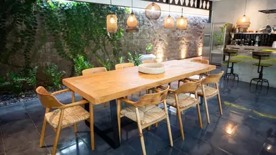 a dining room with a wooden table and chairs at Villa Honeypot Berawa in Canggu
