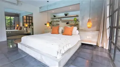 a bedroom with a large white bed with orange pillows at Villa Honeypot Berawa in Canggu