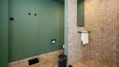 a bathroom with a tiled shower with a toilet at Villa Dreamora by Villa Finder in Seminyak