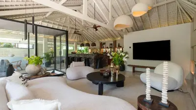a living room with a couch and a tv at Villa Dreamora by Villa Finder in Seminyak