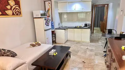 a kitchen with a couch and a table in a room at Jayakarta Bali Apartments in Seminyak