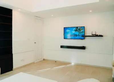a living room with a tv on a white wall at Apartment Nata Umalas in Seminyak