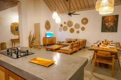a kitchen and living room with a table and chairs at NEW 3BR Fleur De Vie Tranquility Villa in Seminyak in Seminyak