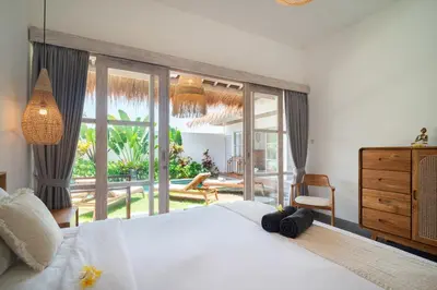 a bedroom with a white bed and a large window at NEW 3BR Fleur De Vie Tranquility Villa in Seminyak in Seminyak