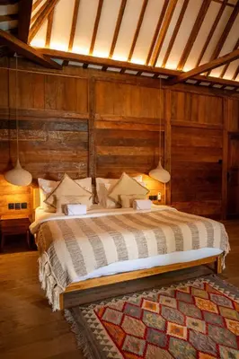a bedroom with a large bed with wooden walls at Tuluscoliving Villa Kuta 4, 2 Bedroom & 2 Bathroom in Ngurah Rai International Airport