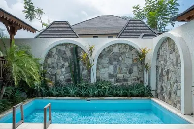 a swimming pool in front of a house at Tuluscoliving Villa Kuta 4, 2 Bedroom & 2 Bathroom in Ngurah Rai International Airport