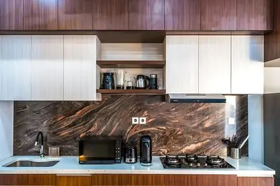 a kitchen with wooden cabinets and a counter top at Modern 2BR Villa in Seminyak Center - Private Pool in Seminyak