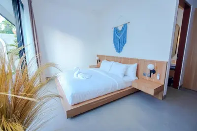 a bedroom with a bed with white sheets at Rama Villa Umalas in Kerobokan