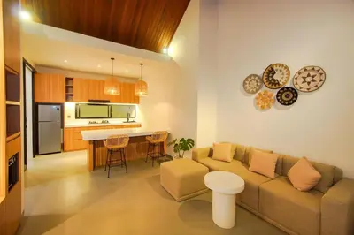 a living room with a couch and a kitchen at Rama Villa Umalas in Kerobokan