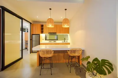 a kitchen with a white counter and stools at Rama Villa Umalas in Kerobokan