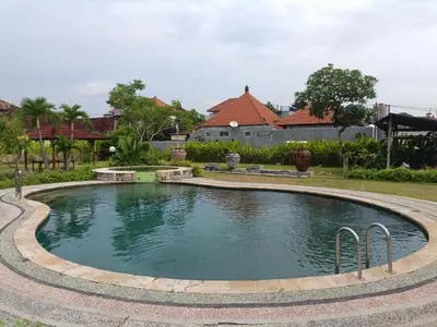 a swimming pool in a yard with houses at Dongsoul Guest House in Legian