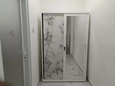 a mirror in a room with a marble wall at Dongsoul Guest House in Legian