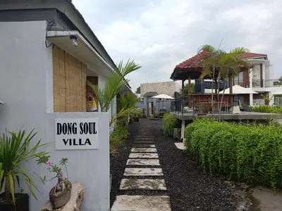 a sign that reads drug south villa next to a house at Dongsoul Guest House in Legian