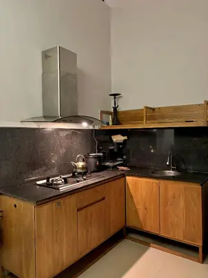 a kitchen with wooden cabinets and a stove at Uma Mari Villa Seminyak in Seminyak