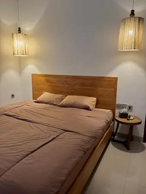 a bed in a bedroom with two lights and a table at Uma Mari Villa Seminyak in Seminyak