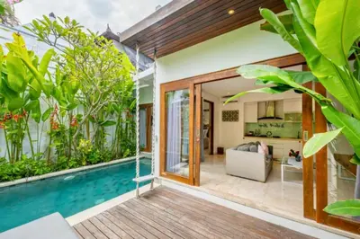 a house with a swimming pool and a living room at Daiva Comfortable 1 BR Private Pool Villa in Jimbaran
