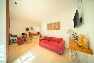 a living room with a red couch and a table at Daiva Comfortable 1 BR Private Pool Villa in Jimbaran