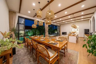 a dining room with a wooden table and chairs at Palm Sugar 2-Chic 3BR Villa in Jimbaran with Pool&Garden in Jimbaran