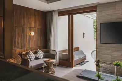 a living room with a couch and a television at Charity Stunning Grand 1 BR Pool Villa With Jacuzzi in Seminyak