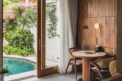 a dining room with a table and a pool at Charity Stunning Grand 1 BR Pool Villa With Jacuzzi in Seminyak