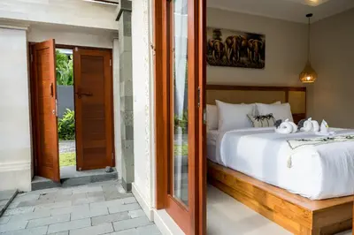a bedroom with a bed and a glass door at Villa Inges 3 Seminyak in Seminyak