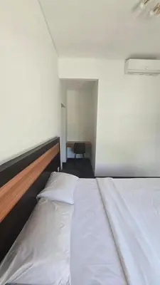 a large white bed in a room with a chair at Villa Don Bose 8 in Jimbaran