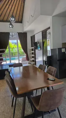 a dining room with a wooden table and chairs at Villa Don Bose 8 in Jimbaran