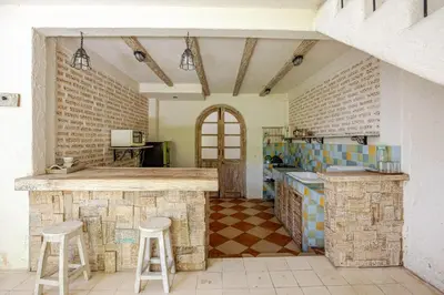 a kitchen with a counter and stools in a room at M-Apartment in Badung