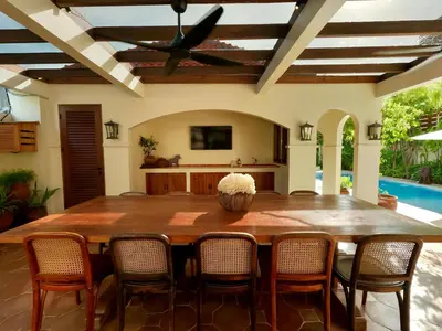 a dining room with a large wooden table and chairs at Casa Mañana Villa Legian, Kuta in Legian