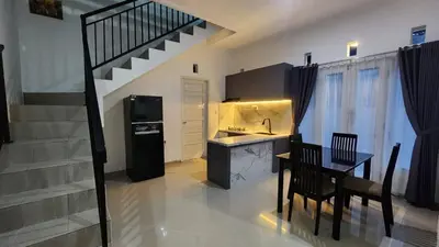 a kitchen with a table and a kitchen with a staircase at House of Tomolowicz in Jimbaran