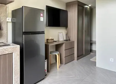 a kitchen with a stainless steel refrigerator and a counter at Olive Athena Guesthouse in Seminyak