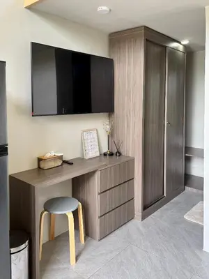 a room with a desk with a tv and a stool at Olive Athena Guesthouse in Seminyak