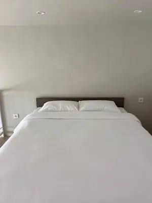 a large white bed with two pillows on it at Olive Athena Guesthouse in Seminyak