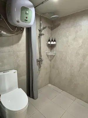 a bathroom with a shower and a toilet in it at Olive Athena Guesthouse in Seminyak