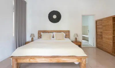a bedroom with a large bed with white sheets at Villa VITA in Seminyak