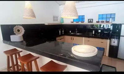 a kitchen with a black counter with stools in it at Villa VITA in Seminyak