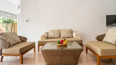 a living room with two couches and a table at Villa VITA in Seminyak