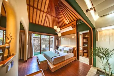 a bedroom with a bed in a room with green walls at Edna Royal 1 BR Private Pool Villa With Jacuzzi in Legian