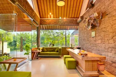 a living room with a green couch and a table at Edna Royal 1 BR Private Pool Villa With Jacuzzi in Legian