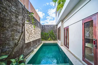 a swimming pool in the courtyard of a house at Azula Cozy Royal 2 BR Private Pool Villa With Jacuzzi in Legian